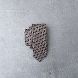 Sandy Eclipse silk tie designed by Niki Fulton. Camel, bronze blue graphic print. 