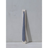 Eclipse silk tie designed by Niki Fulton. A blue & grey graphical print. Displayed on a plinth.
