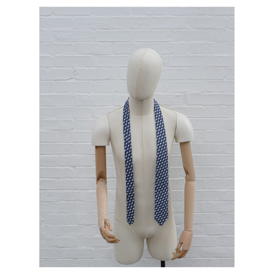 Eclipse silk tie on a mannequin. Blue & grey graphical print. 